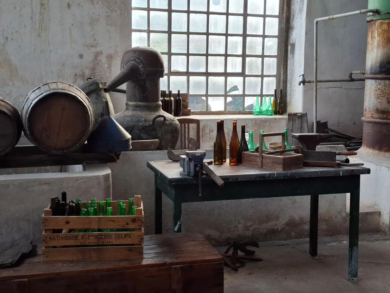 Vintage distillery workshop with old barrels and glass bottles, rustic atmosphere.